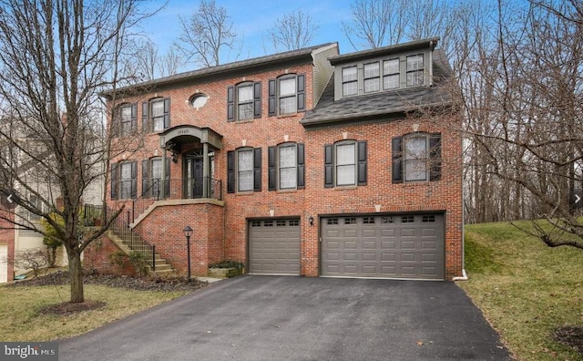 view of front of property featuring brick siding, driveway, an attached garage, and stairs