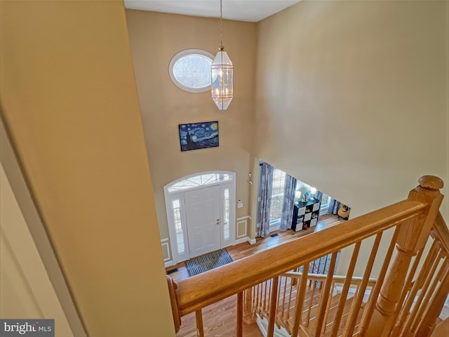 entrance foyer with a high ceiling, baseboards, and a notable chandelier