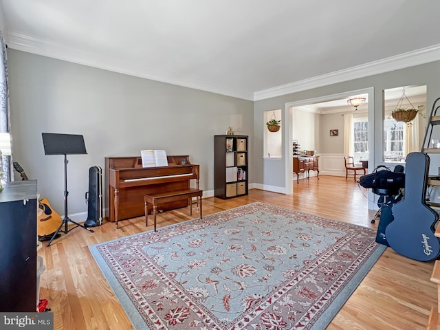 living area with crown molding, baseboards, and wood finished floors