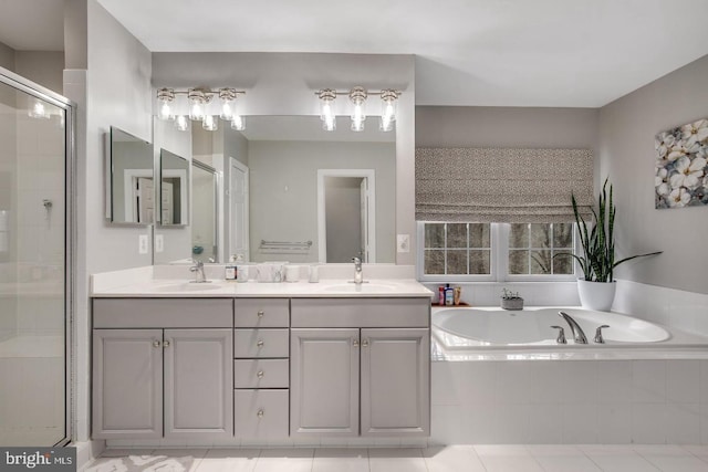 bathroom with a garden tub, double vanity, a stall shower, and a sink