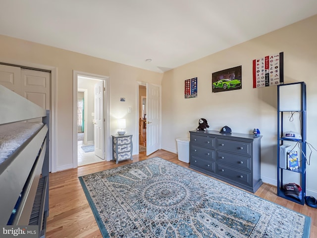 bedroom with light wood-style flooring and baseboards