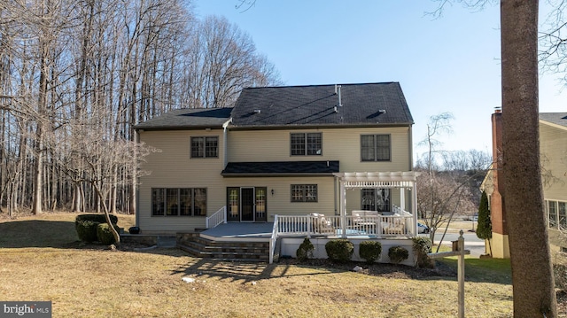 back of house featuring a lawn, a deck, and a pergola