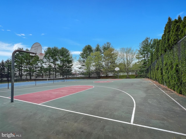 view of sport court with a tennis court, community basketball court, and fence