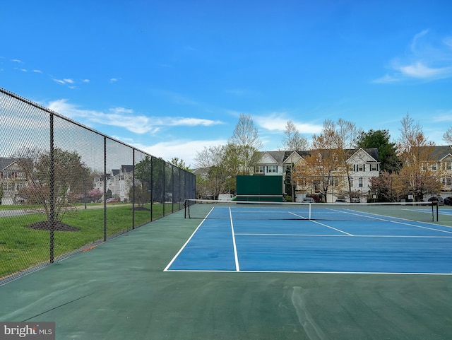 view of sport court with a residential view and fence