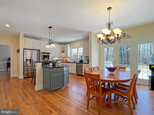 dining room with light wood-type flooring, a notable chandelier, baseboards, and recessed lighting