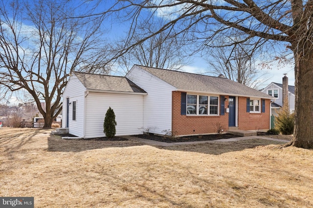 ranch-style home featuring a shingled roof and brick siding