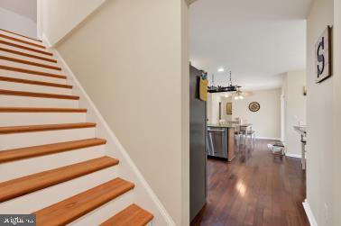 staircase with baseboards and wood finished floors