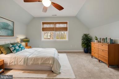 bedroom with lofted ceiling, baseboards, a ceiling fan, and light colored carpet