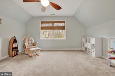 interior space featuring carpet floors, vaulted ceiling, baseboards, and a ceiling fan