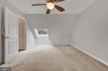 bonus room featuring ceiling fan, lofted ceiling with skylight, carpet flooring, and baseboards