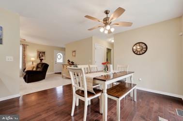 dining room featuring wood finished floors, a ceiling fan, and baseboards