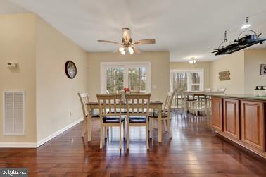 dining room with a healthy amount of sunlight, dark wood-style floors, and visible vents