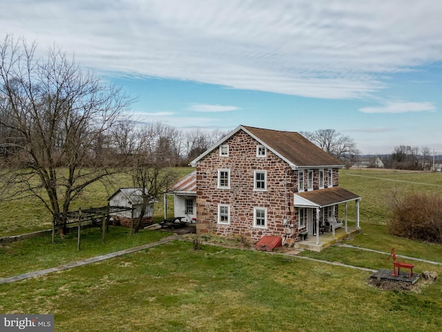 view of side of property featuring a yard and stone siding