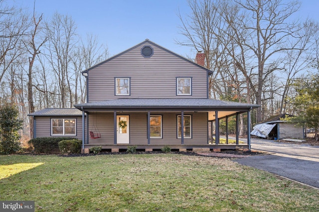 farmhouse inspired home featuring a front lawn, roof with shingles, covered porch, a chimney, and driveway