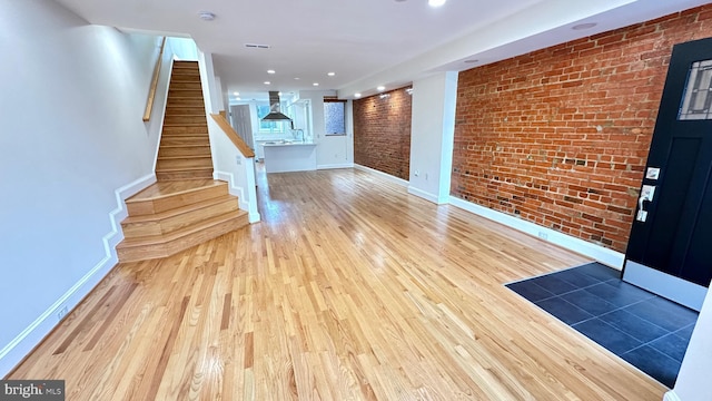 entrance foyer featuring light hardwood / wood-style floors and brick wall