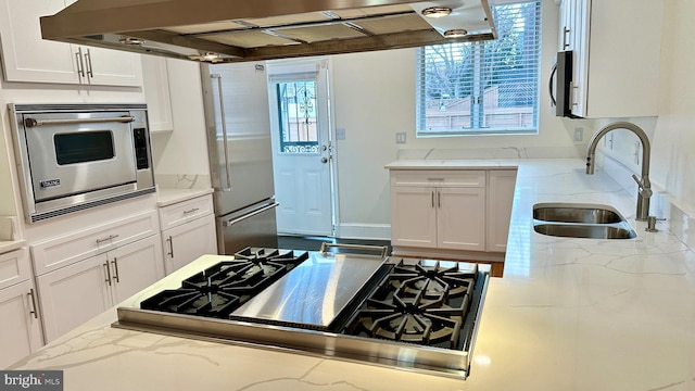 kitchen featuring light stone countertops, sink, extractor fan, appliances with stainless steel finishes, and white cabinets