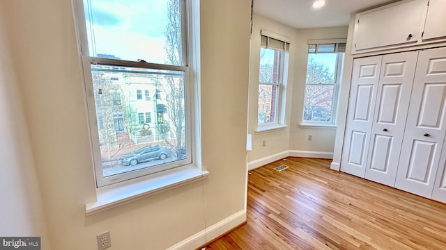 unfurnished bedroom with light wood-type flooring and a closet