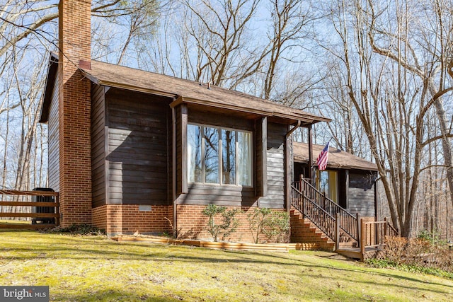 view of front of home featuring a front lawn, a chimney, and stairway