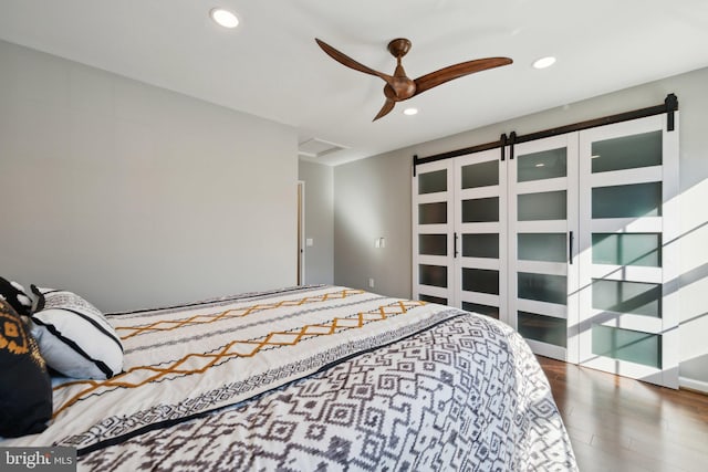 bedroom with dark wood-style floors, attic access, and recessed lighting