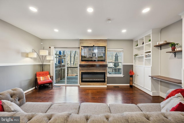 living room featuring plenty of natural light, a fireplace, dark wood finished floors, and recessed lighting