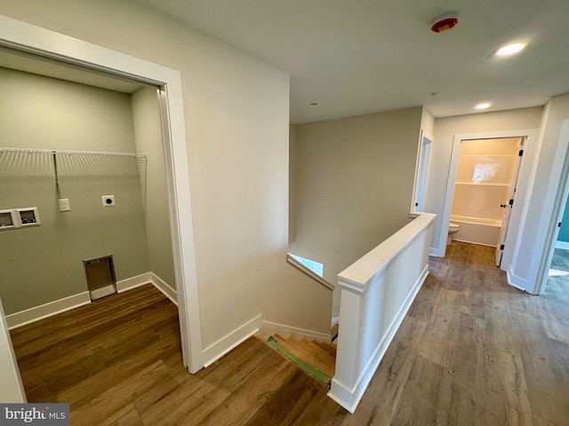 corridor with baseboards, wood finished floors, an upstairs landing, and recessed lighting