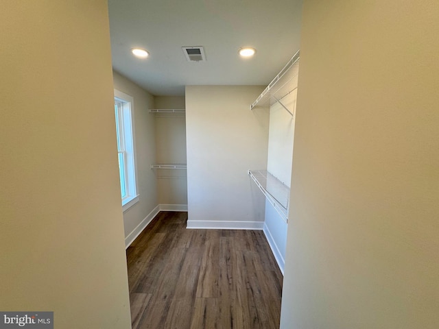 spacious closet with dark wood-type flooring and visible vents