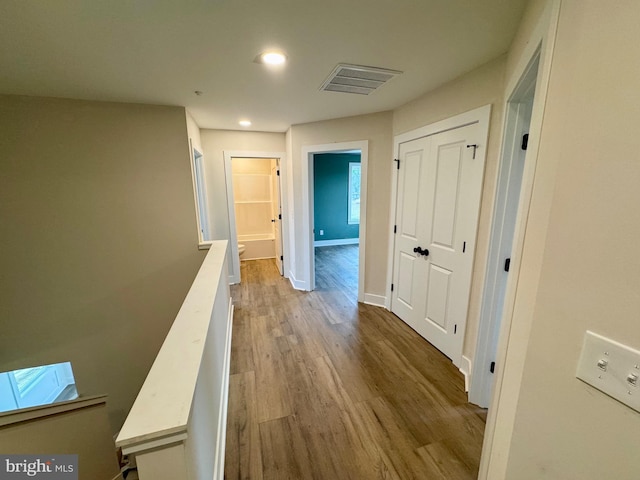 hall featuring an upstairs landing, recessed lighting, baseboards, visible vents, and wood finished floors