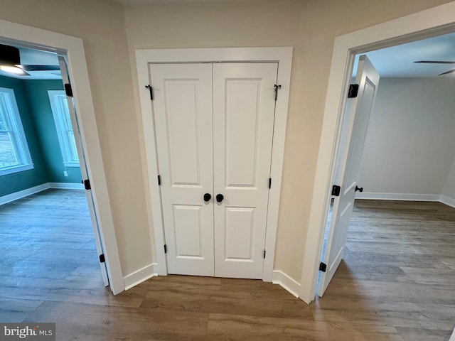 hall featuring baseboards and wood finished floors