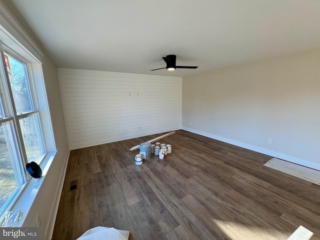 spare room with baseboards, visible vents, wood finished floors, and ceiling fan
