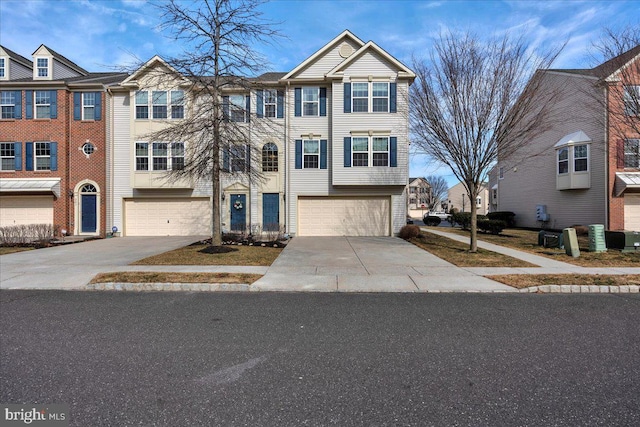 multi unit property with concrete driveway and an attached garage