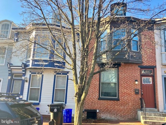 exterior space with entry steps and brick siding