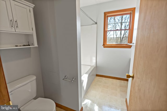 bathroom with washtub / shower combination, baseboards, toilet, and tile patterned floors