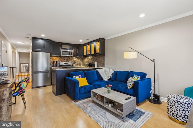 living area featuring light wood-style flooring, baseboards, and crown molding