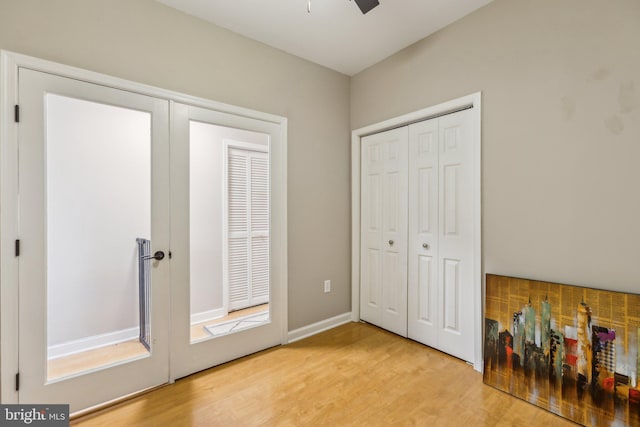 unfurnished bedroom with light wood-style floors, french doors, a closet, and baseboards