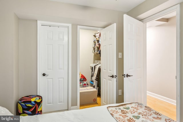 bedroom featuring a closet, light wood-style flooring, and baseboards