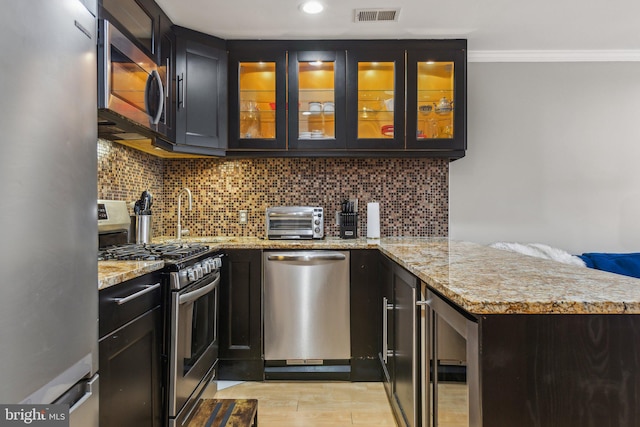 kitchen with light stone counters, wine cooler, visible vents, appliances with stainless steel finishes, and glass insert cabinets