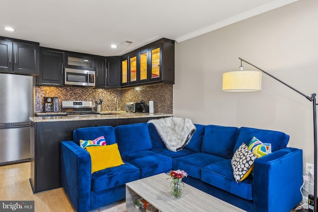 living area featuring ornamental molding, recessed lighting, visible vents, and light wood-style flooring