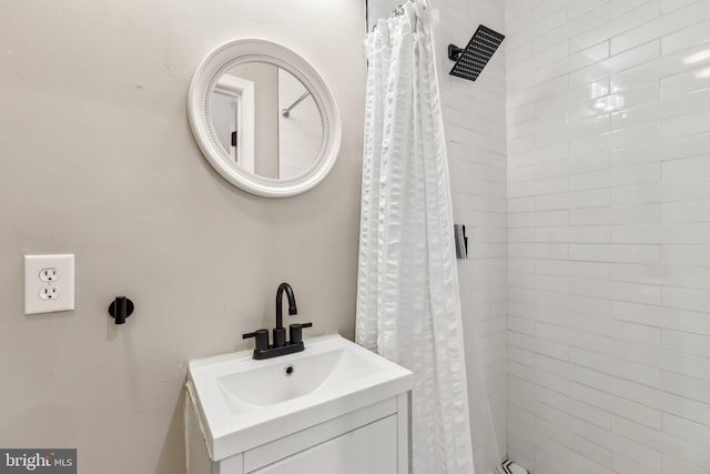 full bathroom with tiled shower and a sink