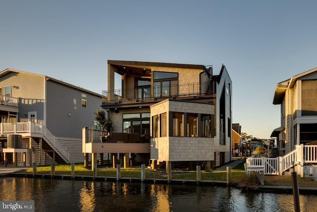 rear view of house with a water view and a balcony