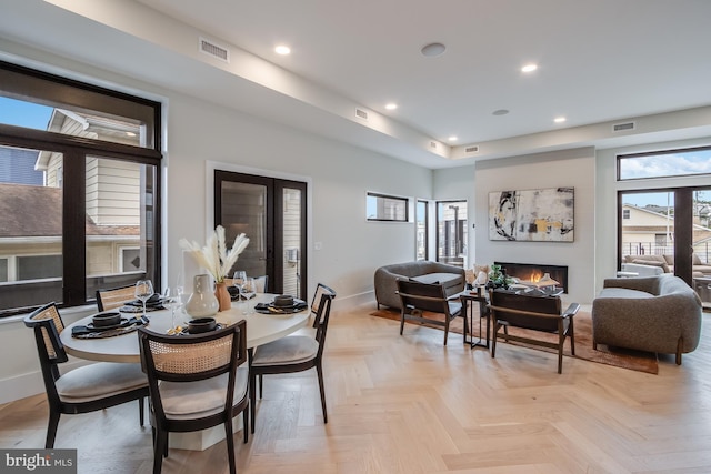 dining room with visible vents, baseboards, a glass covered fireplace, french doors, and recessed lighting