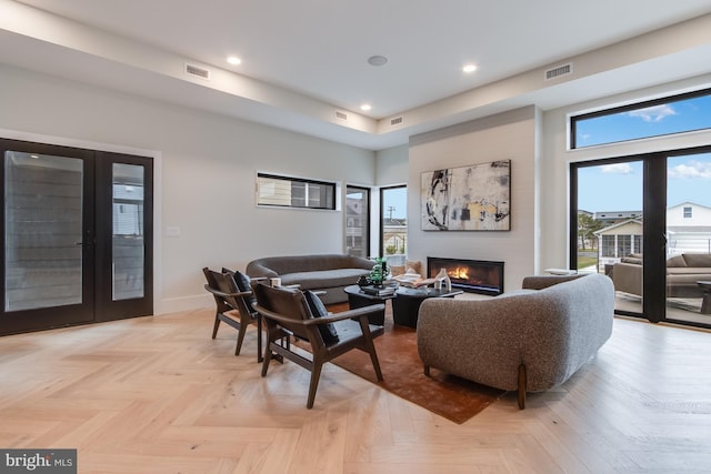 living room featuring french doors, a glass covered fireplace, visible vents, and baseboards