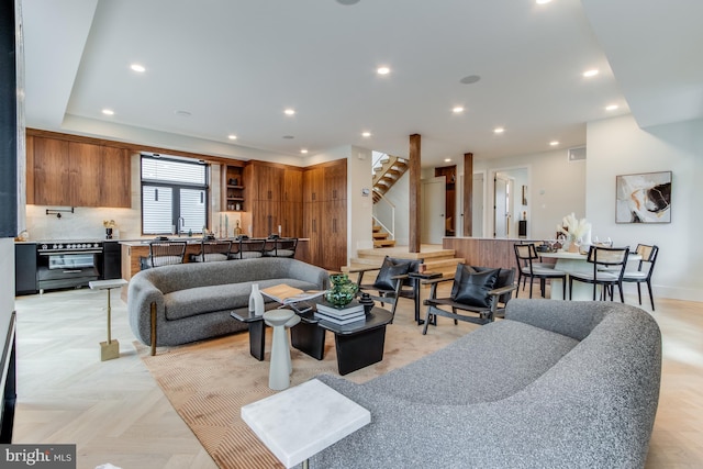 living room with recessed lighting, baseboards, and stairs