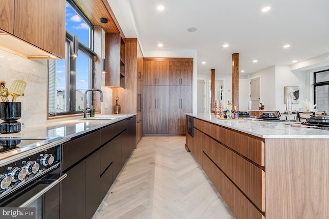 kitchen featuring a spacious island, recessed lighting, a sink, and stove