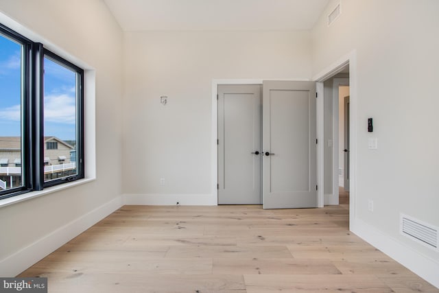 unfurnished room with baseboards, visible vents, and light wood-style floors