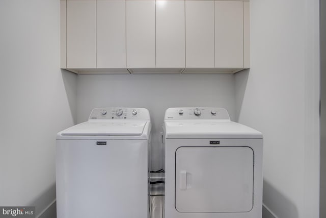 washroom with cabinet space and washer and clothes dryer