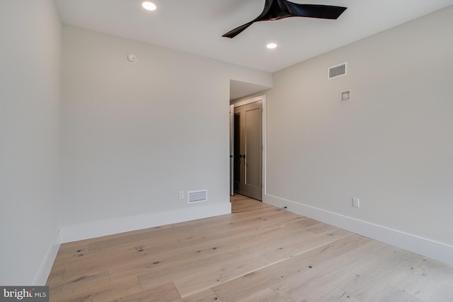 unfurnished room featuring baseboards, visible vents, and wood finished floors