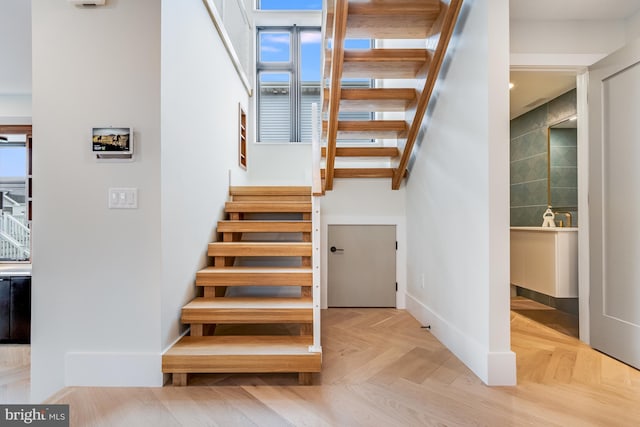 stairway with a healthy amount of sunlight and baseboards