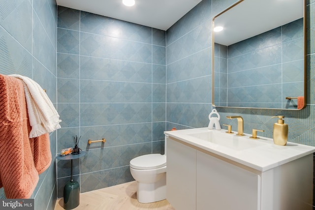 bathroom featuring toilet, tile walls, and vanity