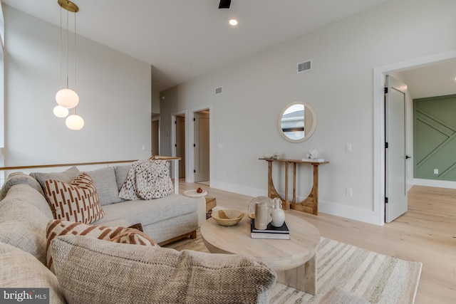 living room with light wood-style flooring, recessed lighting, visible vents, and baseboards