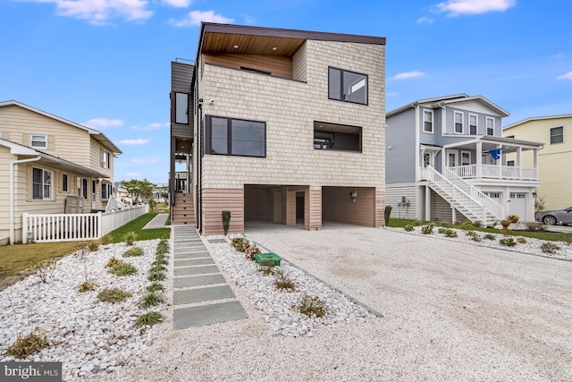 view of front of house with a carport, gravel driveway, and stairway